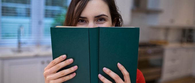Portrait Of Beautiful Woman Covering Her Face With Book